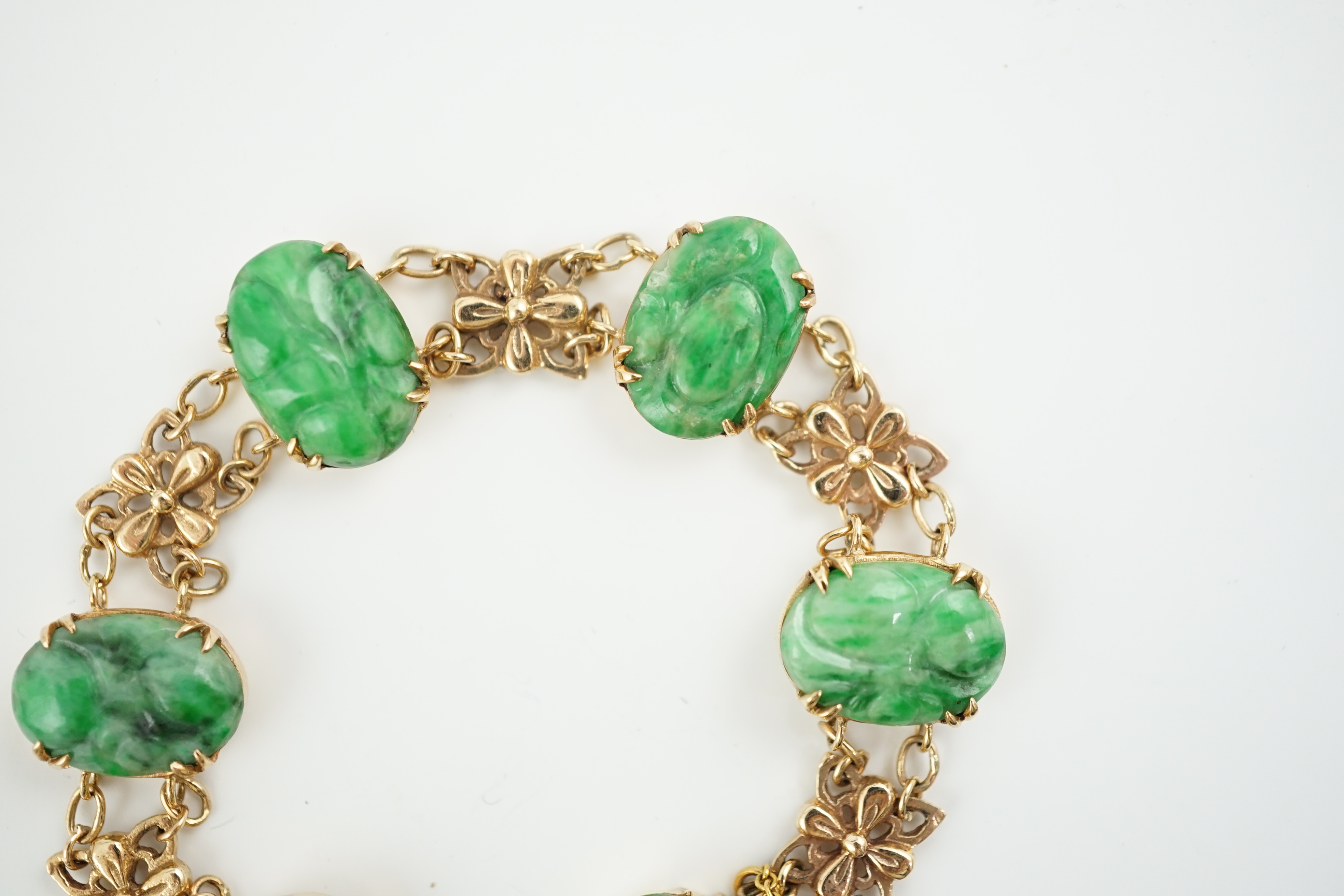 An early 20th century 9ct gold butterfly link and six stone carved jade set bracelet